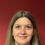 Woman smiling against a red background.